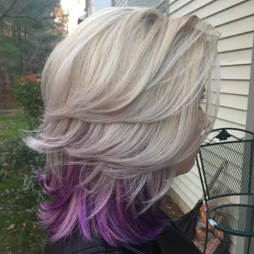 medium blonde layered hairstyle with lavender peek-a-boo highlights