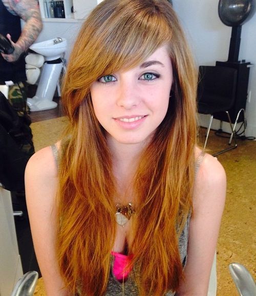 stratificat red hairstyle with long side bangs