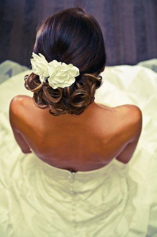 čierna curly wedding updo with hair flowers
