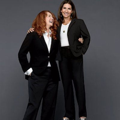 lång red headed woman and short brunette in suits