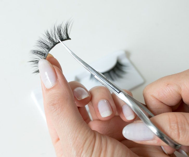 trimning a false lash strip with scissors