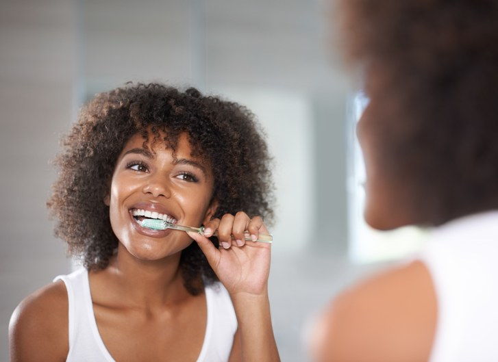 žena brushing teeth