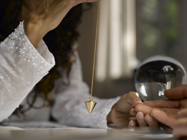 Kvinna fortune teller using pendulum