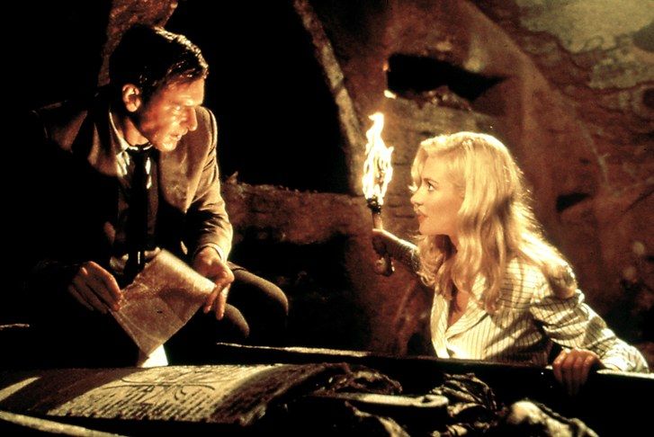 INDIANA JONES & THE LAST CRUSADE: Harrison Ford, Alison Doody holding torch in cave