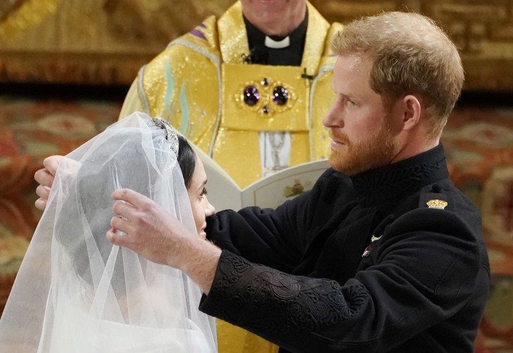 Принце Harry lifts the veil of Meghan Markle during their wedding ceremony in St George's Chapel at Windsor Castle on May 19, 2018 in Windsor, England. 