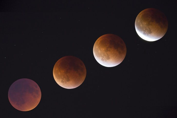 А multiple-exposure image showing the phases of a total lunar eclipse on black sky, Seattle, Washington State, USA