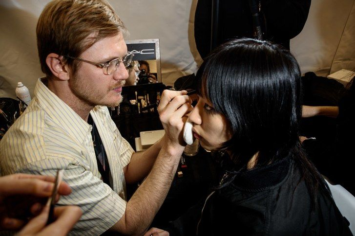 Надокнадити artist Thomas de Kluyver works on a model backstage at the fall 2023 Kenzo show in Paris, France. 
